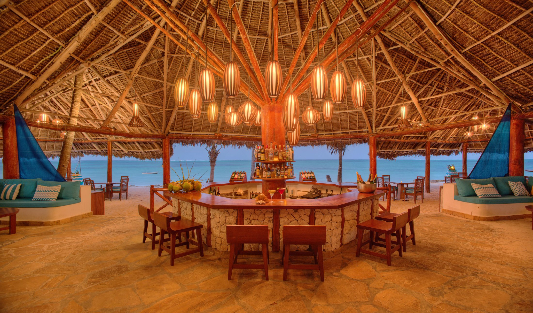 The à-la-carte restaurant under a makuti roof with chandeliers